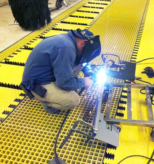 man working on equipment on top of a belt conveyor